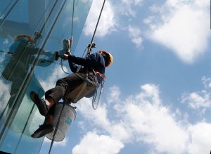 Close,Up,Worker,Cleaning,Mirror,In,High,Bilding,On,Sunny